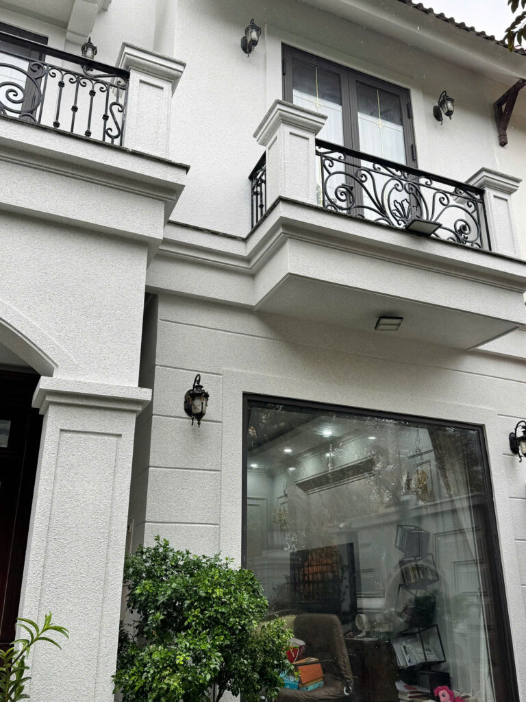 Mặt tiền biệt thự tường sáng và cửa tối minh họa phương án sơn đá trọn gói